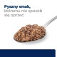 Zbliżenie łyżki karmy dla zwierząt, z teksturowaną, mięsną mieszanką, z tekstem "Pyszny smak, któremu nie sposób się oprzeć" powyżej.