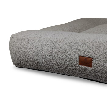 Rechteckiges Haustierbett-Kissen aus grauem Sherpa-Fleece mit Tufting und braunem Lederetikett mit der Aufschrift 'PETLIVING'.