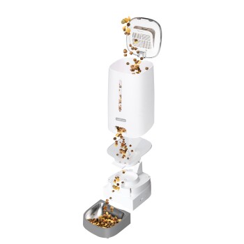 Automatischer Futterspender für Haustiere, der Trockenfutter in eine Edelstahlschüssel ausgibt, mit einem weißen Aufbewahrungsbehälter mit offenem Deckel.