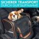 Ein Cavalier King Charles Spaniel sitzt in einem mit Sicherheitsgurt gesicherten Haustierträger im Auto, mit "SICHERER TRANSPORT DURCH GURTAUFNAHME" darüber.