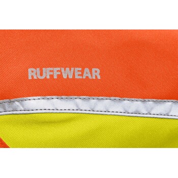 Nahaufnahme eines lebhaften orange-gelben Tieraccessoires mit dem Text 'RUFFWEAR' in Silber, das seinen strapazierfähigen Stoff zeigt.