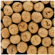 Nahaufnahme von kleinen, runden, braunen Haustierfutter-Kibbles, die auf einem schwarzen Hintergrund verstreut sind.