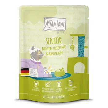 Mjamjam senior huisdierenvoeding zakje met een cartoonkat in een paarse jurk, gelabeld 'Duo von zarter Ente & Kaninchen,' met kwaliteitsiconen.