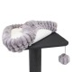 Ein plüschiges graues Haustierbett mit einem flauschigen Rand, das auf einem schwarzen Katzenbaum ruht, mit einem baumelnden Spielzeug-Pompon.