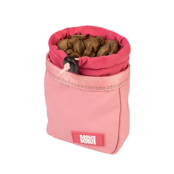 Pinkfarbene Stoff-Leckerlibeutel gefüllt mit braunen Haustierleckerlis, mit Kordelzugverschluss und "Mou Mou"-Etikett.