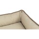 Eine Nahaufnahme eines beige Haustierbettes mit einem weichen, gepolsterten Innenraum und braunen Kanten.
