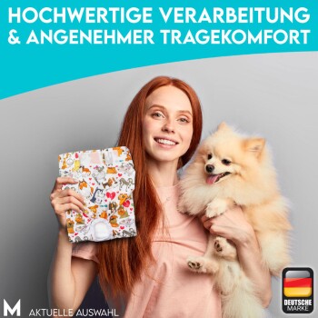 Eine Frau mit langen roten Haaren hält einen Pomeranian und eine bunte Tierprodukt-Tüte vor einem hellgrauen Hintergrund.