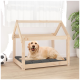 Ein Golden Retriever liegt bequem auf einem grauen Kissen in einem Holz-Hundehäuschen mit einem Satteldach, das in einem hellen Raum steht.