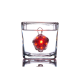 Ein rotes LED-Haustiersicherheitslicht in einem klaren Glas Wasser, das seine helle Beleuchtung und hexagonale Form zeigt.