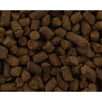 Nahaufnahme dunkelbrauner, trockener Tierfutter-Pellets, gemischte zylindrische und runde texturierte Stücke, die das Bild ausfüllen