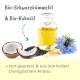 Bio Schwarzkümmelöl und Bio Kokosöl in einer Glasflasche, mit Kokosnüssen, schwarzen Samen und einer blauen Blume; kaltgepresst und biologisch.
