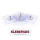 Drei transparente Klebepads mit Metallverschlüssen, beschriftet "KLEBEPADS für eine sichere Fixierung" am Boden.