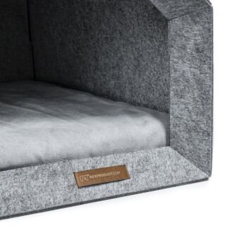 Graues Filz-Haustierbett mit einem weichen Innenkissen, mit einem Lederschild, auf dem "REXPRODUCT" steht.