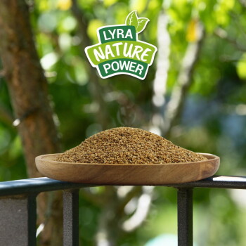 Holzteller gefüllt mit natürlichen Tierfuttergranulaten auf einem Geländer, darüber das Logo „Lyra Nature Power“.