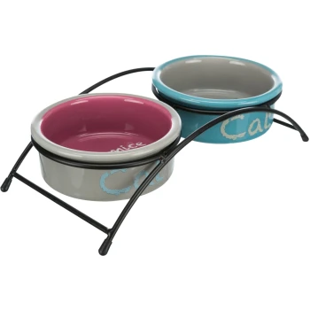 Napf-Set Eat on Feet, Keramik blau/ türkis/ grau/ rosa Doppeltes Futtergeschirr-Set mit einer pinken und einer blauen Keramikschüssel, jede in einem schwarzen Metallständer, mit den Worten 'Katze' und 'Schön'.