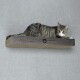 Eine gestreifte getigerte Katze, die auf einem Holzregal vor einem grauen Hintergrund entspannt.