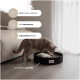 Eine hellbraune Katze spielt mit einem runden schwarzen Katzenbett mit einem Kissen, mit dem Text: "2 in 1 kratzen & schlafen," "inkl. Katzenminze," und mehr.