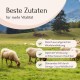 Schafe grasen auf einer grünen Weide mit Text, der hochwertige Zutaten für die Vitalität von Haustieren auf Deutsch hervorhebt.