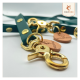 Nahaufnahme von grünen Haustierleinen mit goldenen Beschlägen und Schnapphaken, mit Lederetiketten, die mit "WILDFANG" geprägt sind.