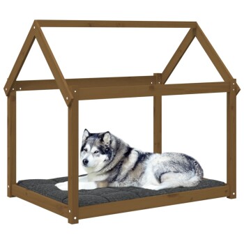 Ein gemütliches Hundebett aus Holz in Form eines Hauses, mit einem grauen Kissen, auf dem ein entspannter Husky liegt.