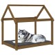 Ein gemütliches Hundebett aus Holz in Form eines Hauses, mit einem grauen Kissen, auf dem ein entspannter Husky liegt.