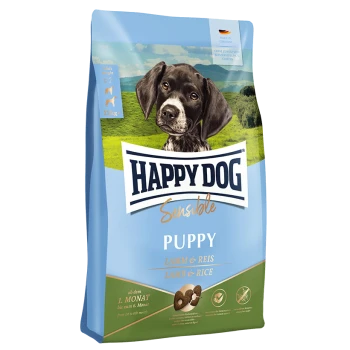 Tüte mit Happy Dog Sensible Welpenfutter, die einen schwarz-weißen Welpen vor einer grünen Landschaft zeigt, beschriftet mit "Lamm & Reis."