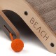 Ein moderner Kratzbaum für Katzen mit einer beigen Textur, einem Holzrahmen und dem Wort "BEACH", das an der Seite eingraviert ist, mit einem orangefarbenen Wollball.