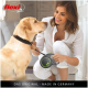 Eine Frau in einem weißen Hemd hält eine grün-schwarze Flexi-Rollleine für Hunde und bereitet sich darauf vor, sie an einen goldenen Labrador anzubringen.