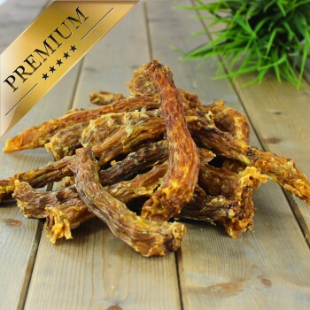 Premium-Hundekauartikel auf einer Holzoberfläche angeordnet, mit einer dekorativen grünen Pflanze im Hintergrund.