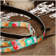 Hundeleine mit Blumenmuster und Max & Molly Markenanhänger auf Holzboden, Katzenpfote im Hintergrund sichtbar.