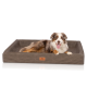 Ein glücklicher Australian Shepherd Hund, der auf einem stilvollen braunen Haustierbett mit einem Logoetikett, das "KNUFFELDUPP" liest, entspannt.
