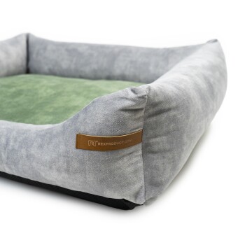 Graues Haustierbett mit einem grünen Kissen, ausgestattet mit einem Lederetikett, auf dem 'RexProduct.com' steht.