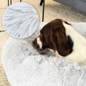 Ein brauner und weißer Hund ruht auf einem flauschigen, hellgrauen Hundebett, mit einem Nahaufnahme-Inset, das den weichen, strukturierten Stoff zeigt.