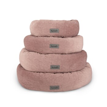 Vier gestapelte runde Haustierbetten in sanften Rosa- und Beigetönen, jedes mit "Scruff's" auf einem grauen Etikett beschriftet.