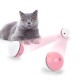 Eine graue Britisch Kurzhaar Katze mit orangefarbenen Augen liegt neben zwei pink-weißen interaktiven Laserspielzeugen, die pinke Laserstrahlen ausstrahlen.