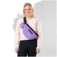 Eine Person in einem hellrosa Sweatshirt steht vor einem grauen Hintergrund und hält eine lila PAIKKA Umhängetasche mit einem kleinen passenden Beutel.