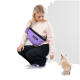 Eine Person in einem hellrosa Sweatshirt und schwarzen Hosen, die eine lila PAIKKA-Tasche trägt, während ein kleiner Hund verspielt nach ihr greift.