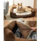 Ein flauschiger Hund, der in einem gemütlichen braunen Haustierbett mit einem weichen grauen Innenraum entspannt, das den abnehmbaren Bezug des Bettes zeigt.