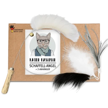 Pappverpackung mit einer Katze in Brille und Schal, beschriftet mit "KATER KASIMIR SCHAFFELL-ANGEL + 3 ANHÄNGER," neben einem gefiederten Spielzeug und einem Holzgriff.