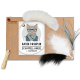 Pappverpackung mit einer Katze in Brille und Schal, beschriftet mit "KATER KASIMIR SCHAFFELL-ANGEL + 3 ANHÄNGER," neben einem gefiederten Spielzeug und einem Holzgriff.