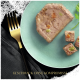Eine Scheibe Gemüse-Haustierfutter-Pâté auf einem hellgrünen Teller mit einer goldenen Gabel und einer dunklen Serviette. Text: "GESCHMACK OHNE KOMPROMISSE."