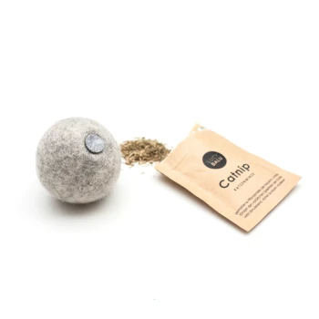 Ein grauer Filz-Katzenspielball neben einem offenen Paket Katzenminze, mit getrockneter Katzenminze, die herausfällt, beschriftet mit "Katzenminze" in schwarzem Text.
