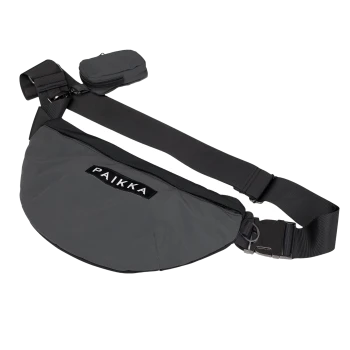 Eine elegante schwarze Tragetasche für Haustiere mit dem Markennamen "PAIKKA" deutlich sichtbar, mit einem verstellbaren Riemen und einer kleinen angehängten Tasche.