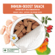 Immun-Boost Snack in einem Behälter, mit braunen, immununterstützenden Leckerlis, umgeben von Hühnerstücken und Kräutern.