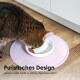 Eine getigerte Katze frisst aus einer weißen Schüssel auf einer rosa Matte, mit dem sichtbaren Text 'Puristisches Design seidenmatte Optik & Schnurrhaarfreundlich.'