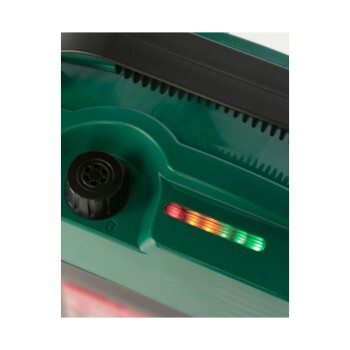 Nahaufnahme eines grünen Haustierpflegewerkzeugs mit einer Stromanzeige, die rote, orange und grüne Stufen zeigt, und einem schwarzen Drehknopf.