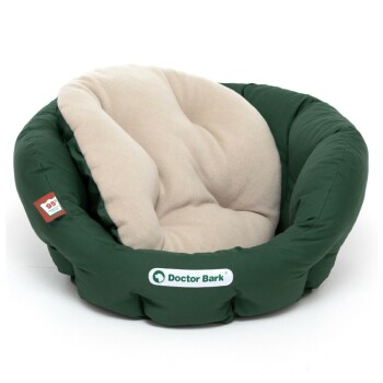 Grünes Haustierbett mit einem weichen beigen Kissen, das das Logo "Doctor Bark" und ein Etikett mit der Angabe 95 % recycelte Materialien zeigt.