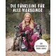 Eine Frau in einem kastanienbraunen Poncho sitzt draußen mit zwei Hunden und einer Hundeleine. Text: 'Die Führleine für alle Vierbeiner' und 'Für mittelgroße & große Hunde.'