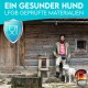 Eine Person steht neben einem weißen Hund vor einer rustikalen Holzhütte, mit Text darüber, der besagt "Ein gesunder Hund" und "LFGB geprüfte Materialien."