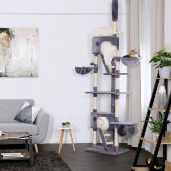 Ein hoher, grauer Katzenbaum mit mehreren Ebenen und Kratzpfosten, mit drei Katzen: zwei weißen Katzen und einer getigerten, die sich entspannen und spielen.